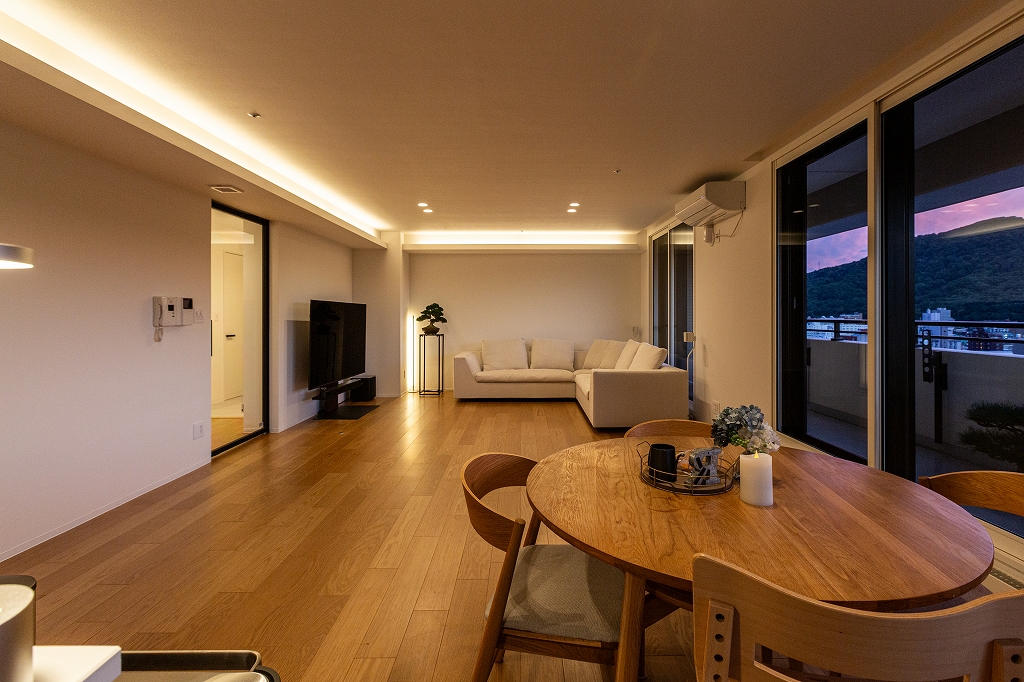 リノベーション後：間接照明が映えるシンプルなLDK全景。夜の様子。