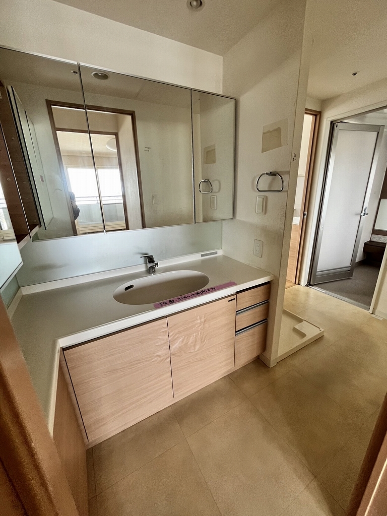 リノベーション前：綺麗だが、面材のシートがよれている洗面台。