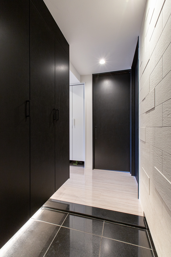 リノベーション後：LIXILエコカラット ヴァルスロックを使った玄関ホール、足元に間接照明、パナソニック コンポリアの収納棚